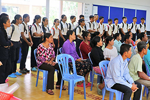 JPA Image Gallery - Students stand behind their parents as they listen to a presentation from teaching staff - Jay Pritzker Academy, Siem Reap, Cambodia