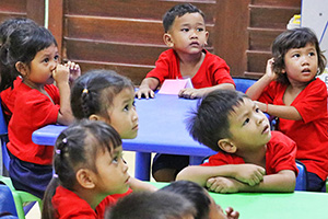 JPA Image Gallery - Preschool students listening at their tables - Jay Pritzker Academy, Siem Reap, Cambodia