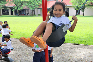 JPA Image Gallery - Primary student smiles on the swing at recess - Jay Pritzker Academy, Siem Reap, Cambodia