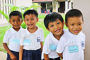 JPA Image Gallery - Young primary students smiling for the camera - Jay Pritzker Academy, Siem Reap, Cambodia