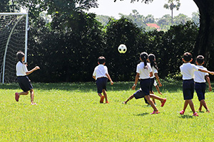 JPA Image Gallery - Primary students chasing a soccer ball at recess - Jay Pritzker Academy, Siem Reap, Cambodia