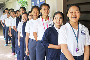 JPA Image Gallery - Students smile as they wait in the queue - Jay Pritzker Academy, Siem Reap, Cambodia