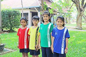 JPA Image Gallery - 4 primary students modeling t-shirts with JPA values - Jay Pritzker Academy, Siem Reap, Cambodia