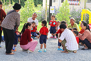 JPA Image Gallery - Parents and preschool students gathered outside enjoying activity - Jay Pritzker Academy, Siem Reap, Cambodia