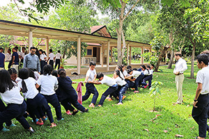 JPA Image Gallery - High school students working together in tug-of-war for Khmer New Year celebration - Jay Pritzker Academy, Siem Reap, Cambodia