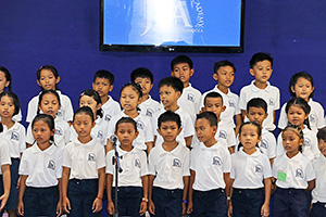 JPA Image Gallery - Primary students singing at musical performance at assembly - Jay Pritzker Academy, Siem Reap, Cambodia