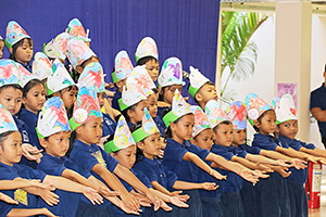 JPA Image Gallery - Kindergarten students perform at assembly wearing headbands about caring for the planet - Jay Pritzker Academy, Siem Reap, Cambodia