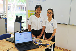 JPA Image Gallery - Two female high school students pose by the computers in IT - robotics class - Jay Pritzker Academy, Siem Reap, Cambodia