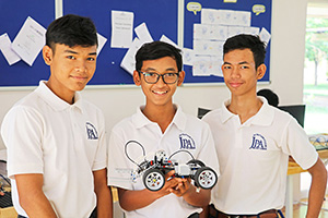 JPA Image Gallery - Three male high school students pose with their robot  - Jay Pritzker Academy, Siem Reap, Cambodia