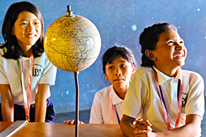 JPA Image Gallery - Students smile near globe on an excursion to Phnom Penh - Jay Pritzker Academy, Siem Reap, Cambodia