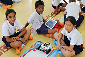 JPA Image Gallery - Middle school students sit with their robot and tablet, waiting instructions for their next task - Jay Pritzker Academy, Siem Reap, Cambodia
