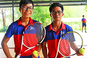 JPA Image Gallery - Two high school tennis players in sport uniform stop for a photo - Jay Pritzker Academy, Siem Reap, Cambodia