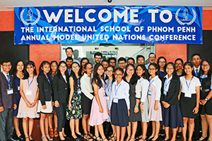 JPA Image Gallery - Model UN delegates pose with their teachers under the event banner at International School of Phnom Penh - Jay Pritzker Academy, Siem Reap, Cambodia