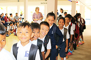 JPA Image Gallery - Happy primary students lined up with backpacks - Jay Pritzker Academy, Siem Reap, Cambodia