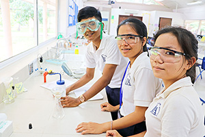 JPA Image Gallery - High school student with protective eyewear working on a chemistry experiment - Jay Pritzker Academy, Siem Reap, Cambodia