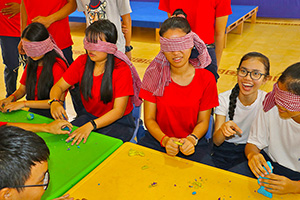 JPA Image Gallery - Blindfolded students engage in sensory activity with playdough - Jay Pritzker Academy, Siem Reap, Cambodia
