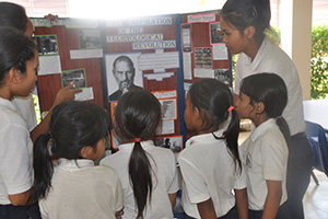 JPA Image Gallery - Primary students listen to older students explaining a display about the technological revolution - Jay Pritzker Academy, Siem Reap, Cambodia
