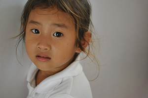 JPA Image Gallery - Primary student looks at the camera - Jay Pritzker Academy, Siem Reap, Cambodia