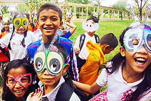 JPA Image Gallery - Students laugh as they don masks - Jay Pritzker Academy, Siem Reap, Cambodia