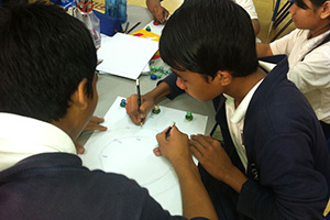 JPA Image Gallery - Students work together on their solar system diagram - Jay Pritzker Academy, Siem Reap, Cambodia
