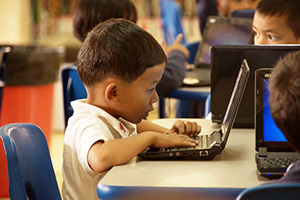 JPA Image Gallery - A primary student focuses on a question on his laptop - Jay Pritzker Academy, Siem Reap, Cambodia